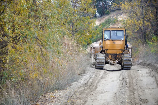 Agregado de cantera con maquinaria pesada. Excavadora cargadora Caterpillar con retroexcavadora que conduce a la cantera del sitio de construcción — Foto de Stock