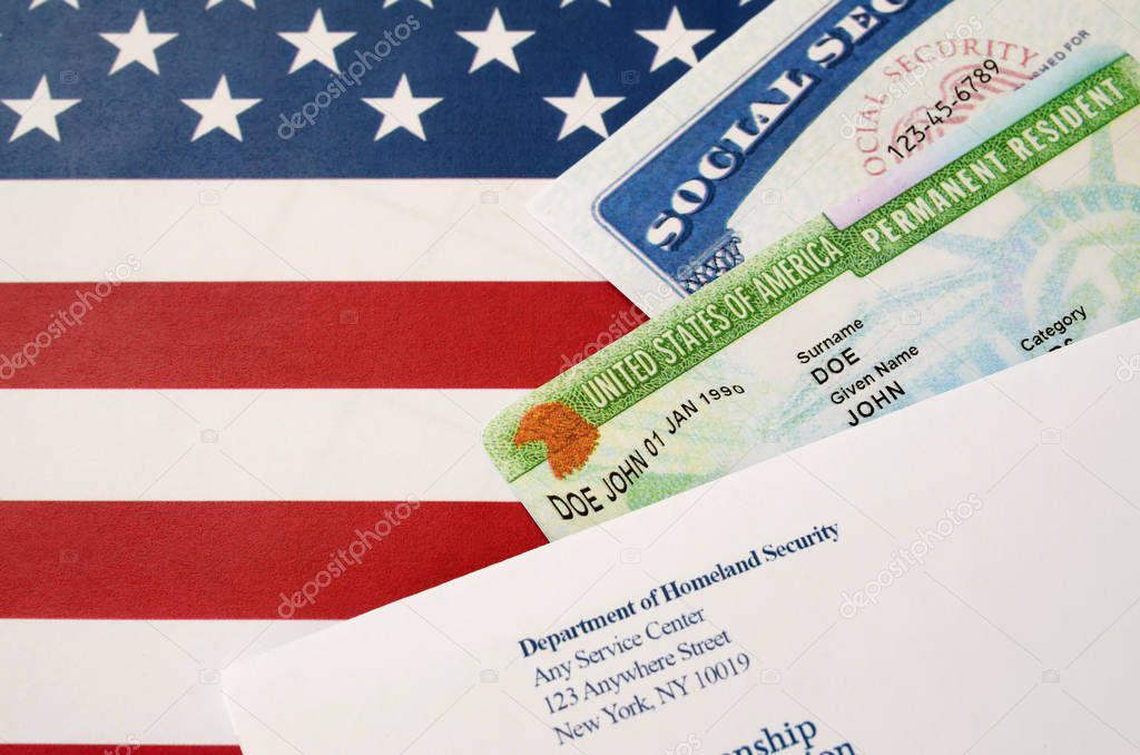 United states permanent resident green card from dv-lottery with social security number lies with USCIS envelope on US flag