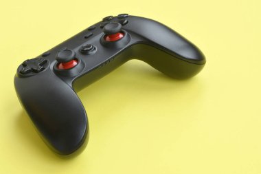Sarı arka planda modern siyah video oyunu denetleyicisi. Video oyunu Speedrun konsepti veya Esports yarışması meydan okuması
