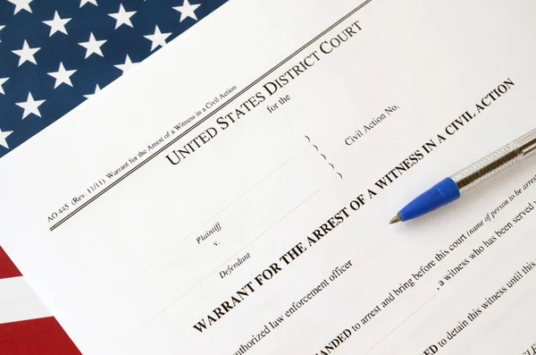 District court warrant for the arrest of a witness in a civil action papers and blue pen on United States flag. Permission to witness arrest — Stockfoto