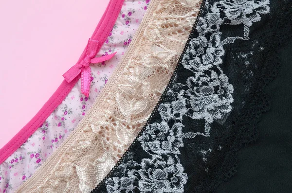 White, black and pink women underwear with lace on pink background with copy space. Advertising for shop of beautiful and comfortable women underwear