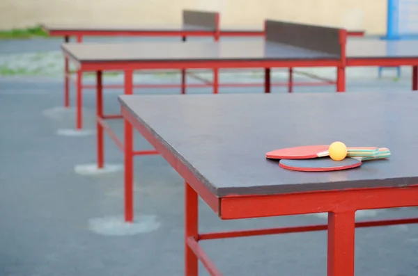 Raquetes e bola na mesa de pingue-pongue no quintal esporte ao ar livre. Conceito ativo de esportes e treinamento físico — Fotografia de Stock