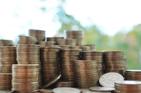 Grande quantidade de brilhante ucraniano velho 1 hryvnia pilhas de moedas fechar em cima da mesa de madeira em árvores verdes pano de fundo. O conceito de negócio e vida rica na Ucrânia — Fotografia de Stock