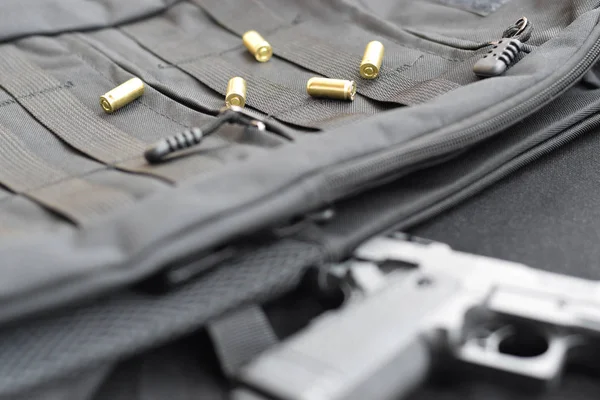 Balas de 9mm e pistola estão em uma mochila tática preta — Fotografia de Stock