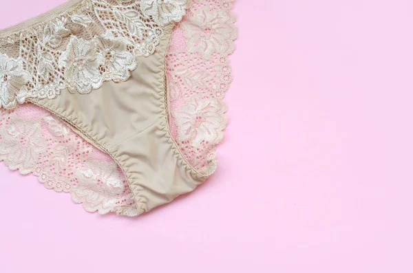 Ropa interior de mujer beige con encaje sobre fondo rosa con espacio para copiar. Concepto de blogger de belleza. Ropa interior romántica para la tentación de San Valentín — Foto de Stock