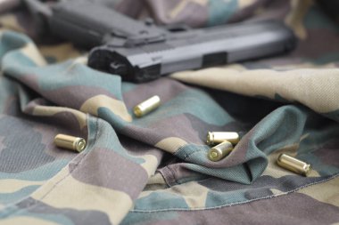 9mm 'lik mermiler ve tabancalar katlanmış yeşil kumaşın üzerinde duruyor. Atış menzili ya da savunma kiti.
