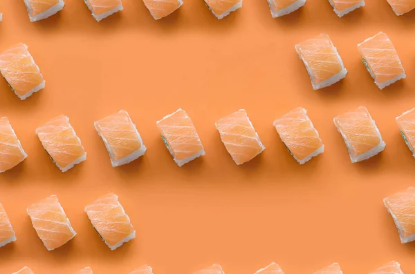 Филадельфия роллы с лосося на оранжевом фоне. Минимализм вид сверху плоский узор с японской едой — стоковое фото