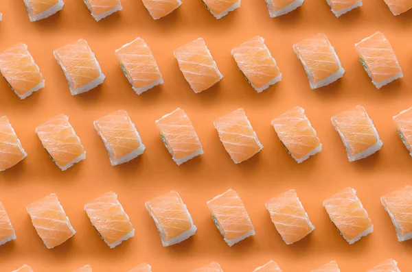 Philadelphie roule avec du saumon sur fond orange. Minimalisme vue de dessus motif plat laïc avec de la nourriture japonaise — Photo