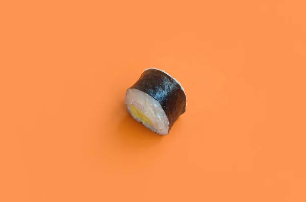 Classico rotolo di sushi nero su sfondo arancione brillante — Foto Stock