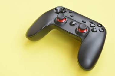 Sarı arka planda modern siyah joystick. Video oyunu zorlukları ve yarışma konsepti