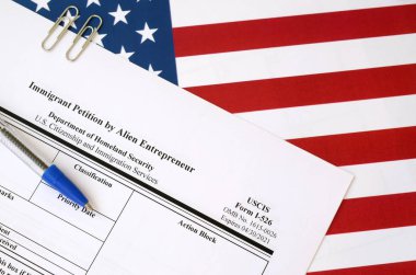 Yabancı Girişimci 'nin I-526 göçmen dilekçesi ABD bayraklarında İç Güvenlik Bakanlığı' ndan mavi kalemle duruyor.