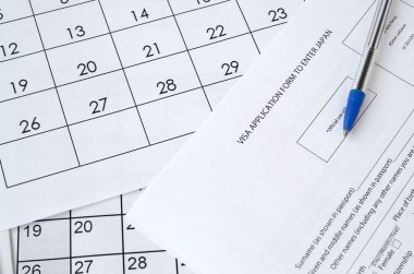 Japonya 'ya girmek için vize başvuru formu ve kağıt takvim sayfasına mavi kalem