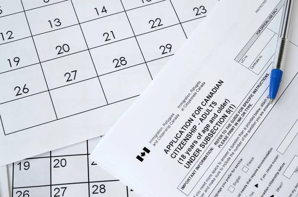 Solicitud de ciudadanía canadiense para adultos y pluma azul se encuentra en la página del calendario —  Fotos de Stock