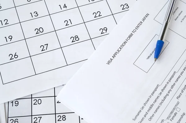 Visa application form to enter Japan and blue pen on paper calendar page — Stockfoto