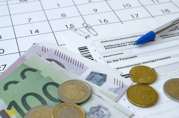 German tax form with pen and european money bills lies on office calendar. Taxpayers in Germany using euro currency to pay taxes Stock Image