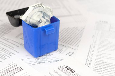 Birçok Amerikan vergi formları ve buruşuk yüz dolarlık banknotlar.