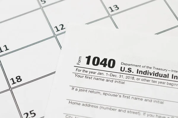 IRS Form 1040 Individual Income Tax Return blank lies on empty calendar page