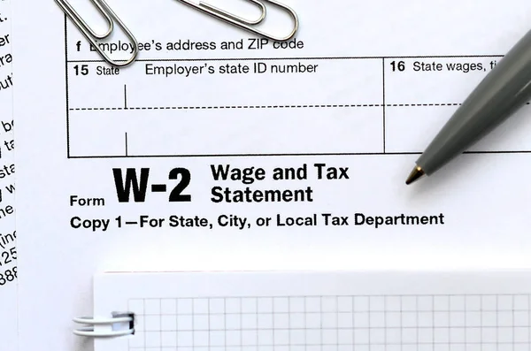 La pluma y el cuaderno en el formulario de impuestos W-2 Salario y declaración de impuestos . — Foto de Stock