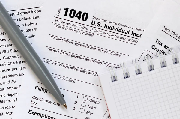 The pen and notebook is lies on the tax form 1040 U.S. Individual Income Tax Return. The time to pay taxes — Stock Photo, Image