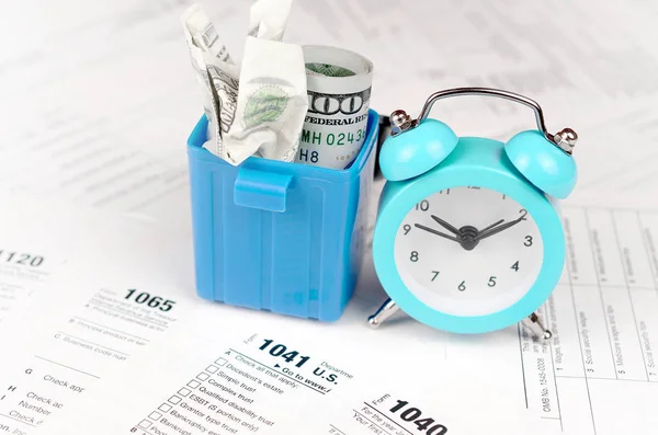 Many american tax blank forms with blue alarm clock and crumpled