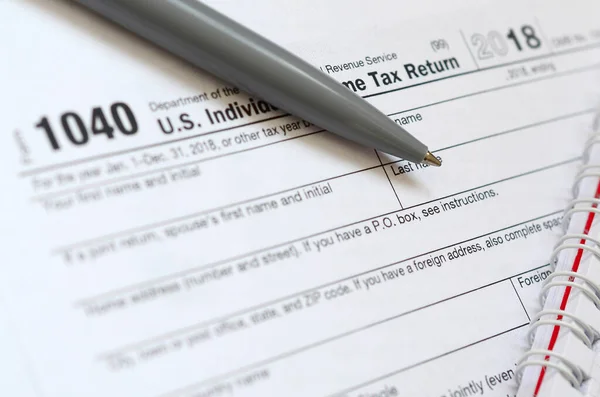 A caneta e caderno está no formulário de imposto 1040 U.S. Individua — Fotografia de Stock