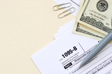 Irs Form 1095-B Sağlık Kapsamı Vergi Vergisi boş yalanlar Kalem ve takvim sayfasında birçok yüz dolarlık banknotlar