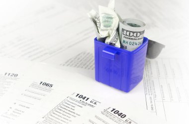 Birçok Amerikan vergi formları ve buruşuk yüz dolarlık banknotlar.