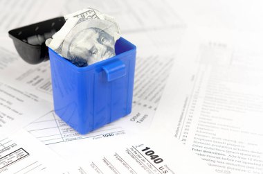 Birçok Amerikan vergi formları ve buruşuk yüz dolarlık banknotlar.