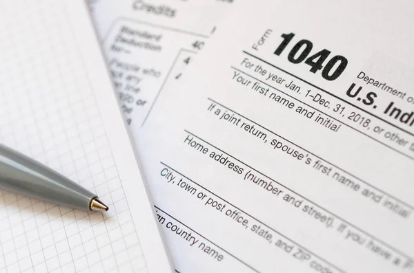A caneta e caderno está no formulário de imposto 1040 U.S. Individua — Fotografia de Stock