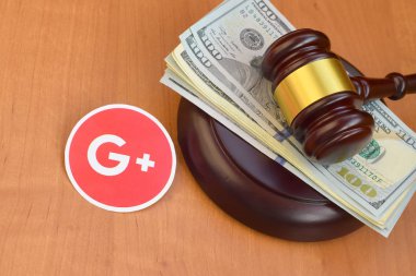 KHARKOV, UKRAINE - FEBRUARY 17, 2020: Google plus paper logo lies with judge gavel and hundred dollar bills. Entertainment lawsuit concept