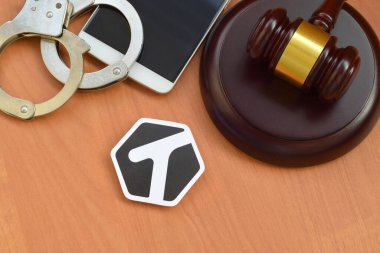 KHARKOV, UKRAINE - FEBRUARY 17, 2020: Tagged paper logo lies with wooden judge gavel, smartphone and handcuffs. Entertainment lawsuit concept