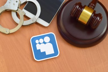 Kharkov, Ukrayna - 17 Şubat 2020: Myspace kağıt logosu ahşap yargıç tokmağı, akıllı telefon ve kelepçeli. Eğlence davaları konsepti