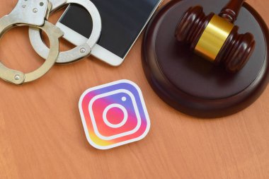 Kharkov, Ukrayna - 17 Şubat 2020: Instagram kağıt logosu ahşap yargıç tokmağı, akıllı telefon ve kelepçeli. Eğlence davaları konsepti
