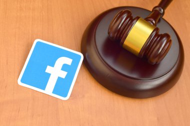 KHARKOV, UKRAINE - FEBRUARY 17, 2020: Facebook paper logo lies with wooden judge gavel. Entertainment lawsuit concept