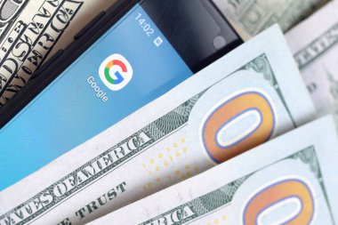 Kharkov, Ukrayna - 6 Şubat 2020: Google uygulamalı akıllı telefon ekranı ve bir sürü yüz dolarlık banknot. İş ve sosyal ağ kavramı