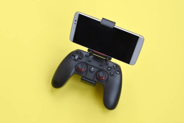 Kharkov, Ukrayna - 19 Ocak 2020: Gamesir g3s modern siyah oyun alanı sarı arka planda akıllı telefon için yakın plan