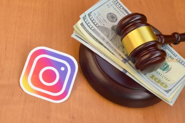 Kharkov, Ukrayna - 17 Şubat 2020: Instagram kağıt logosu yargıç tokmağı ve yüz dolarlık banknotlar içeriyor. Eğlence davaları konsepti