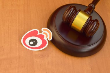 Kharkov, Ukrayna - 17 Şubat 2020: Weibo kağıt logosu ahşap yargıç tokmağıyla kaplıdır. Eğlence davaları konsepti
