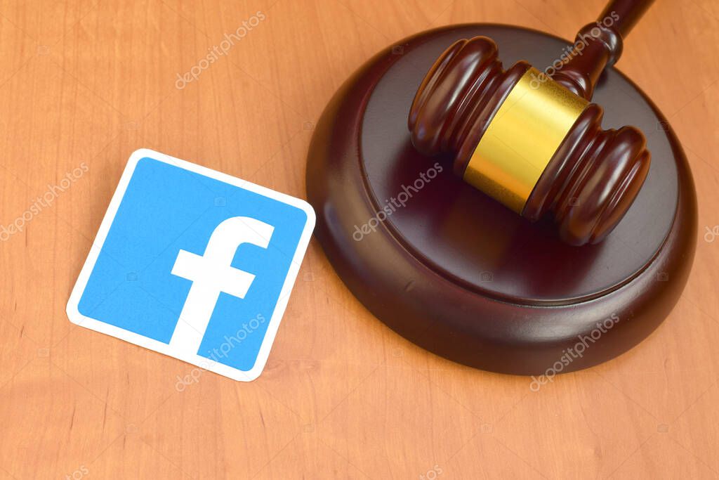 KHARKOV, UKRAINE - FEBRUARY 17, 2020: Facebook paper logo lies with wooden judge gavel. Entertainment lawsuit concept