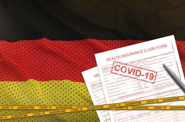 Alman bayrağı ve sağlık sigortası talep formu. Üzerinde de Coperid-19 damgası var. Coronavirus veya salgın 2019-nCov virüs konsepti