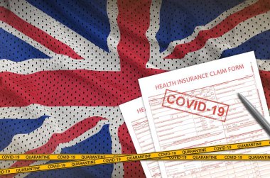 Büyük Britanya bayrağı ve sağlık sigortası başvuru formu. Üzerinde de covid-19 damgası var. Coronavirus veya salgın 2019-nCov virüs konsepti