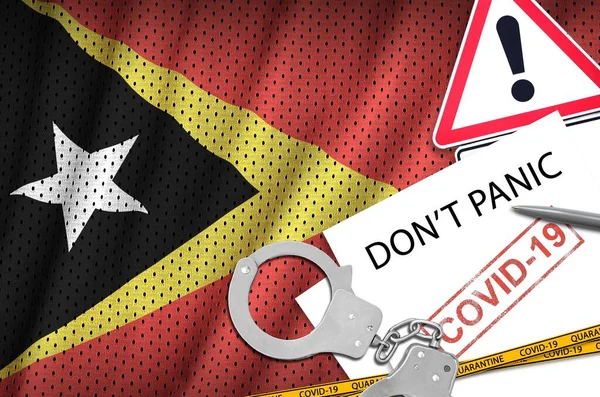 Timor Leste flag and police handcuffs with inscription Don't panic on white paper. Coronavirus or pandemic 2019-nCov virus concept