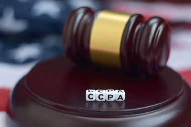 Adalet tokmağı ve CCPA kısaltması arka planda Amerikan bayrağı ile yakın çekim. California tüketicileri koruma eylemi
