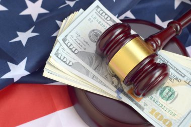 Yargıç Tokmak ve Amerika Birleşik Devletleri bayrağı için para. ABD bayraklarındaki kötü niyet hakimi altında yüzlerce dolarlık banknotlar. Yargılama ve rüşvet kavramı