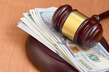 Yargıç Tokmak ve para kahverengi ahşap masada. Mahkeme masasında, hakim kasıtlı yüzlerce dolarlık banknotlar var. Yargılama ve rüşvet kavramı