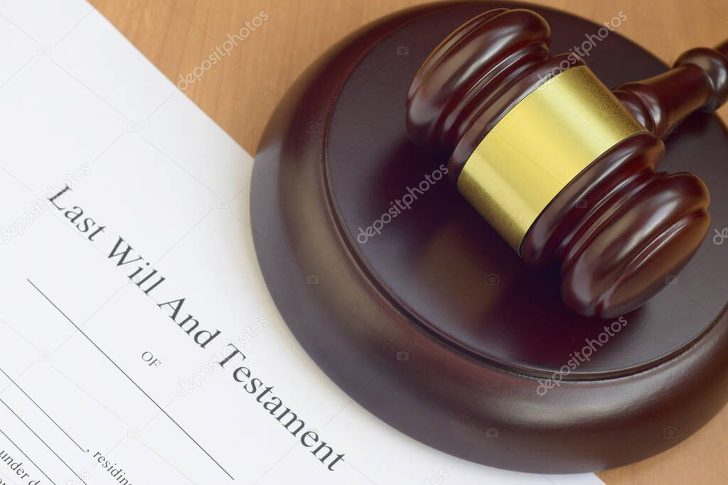 Justice mallet and Last Will and Testament blank document on wooden court table close up