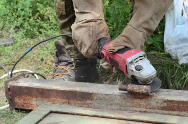 Dışarıdaki çelik yapıda elektrikli tekerlek gıcırdıyor. Koruyucu eldivenli eski bir işçi metal kapıyı öğütücüyle kesiyor. Demir öğütürken kıvılcımlar