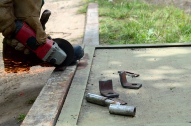 Dışarıdaki çelik yapıda elektrikli tekerlek gıcırdıyor. Koruyucu eldivenli eski bir işçi metal kapıyı öğütücüyle kesiyor. Demir öğütürken kıvılcımlar