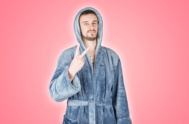 Mavi bornozlu beyaz sakallı genç adamın portresi pembe arka planda izole edilmiş zafer ya da barış jestini gösteriyor. Mutlu duygular