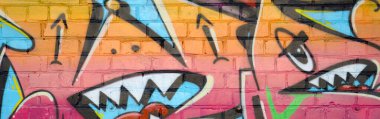 Eski tuğla duvardaki graffiti resimlerinin soyut renkli bir parçası. Yazılmamış mektupların ve renkli lekelerin olduğu sokak sanatı kompozisyonu. Kırmızı renklerde alt kültür arkaplan dokusu